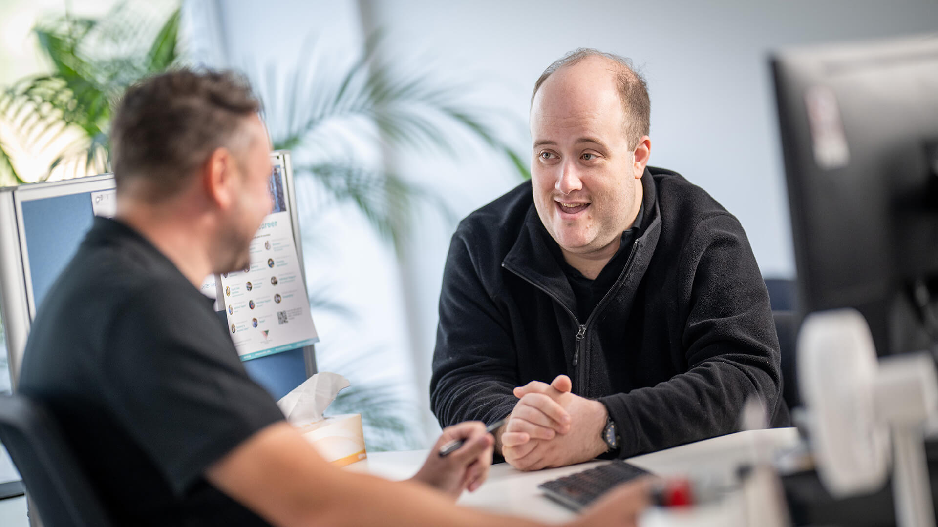 A man with disability talking about inclusive employment with an APM consultant